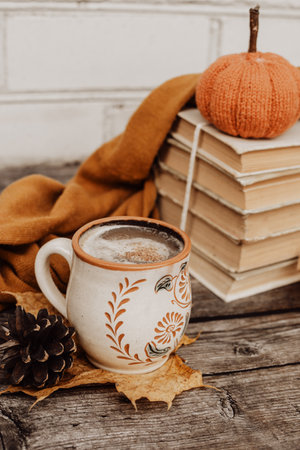 Hot spicy coffee and pile of old books on wooden backgroundの写真素材