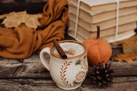 Hot spicy coffee and pile of old books on wooden backgroundの写真素材