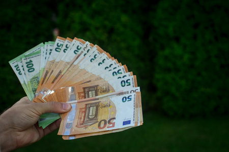 Euro banknotes in man hands, green background