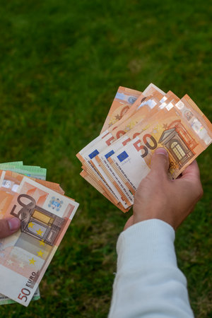 Euro banknotes in man hands, green background