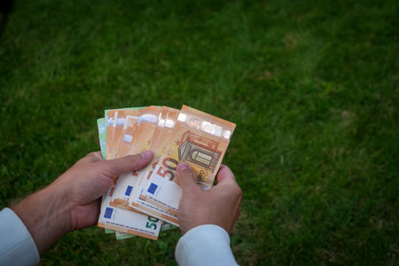 Euro banknotes in man hands, green backgroundの写真素材