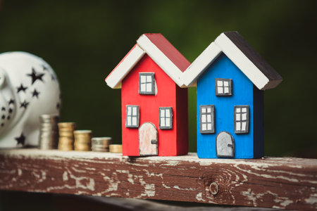 Saving money for new house, piggy bank, euros and small wooden houses on vintage wooden table outdoorsの写真素材