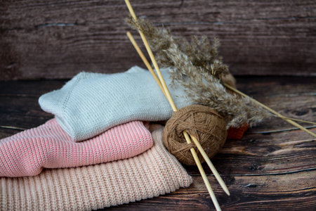 The pile of knitted sweaters on dark brown backgroundの写真素材
