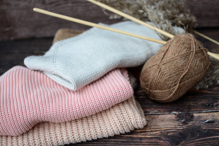 The pile of knitted sweaters on dark brown backgroundの写真素材