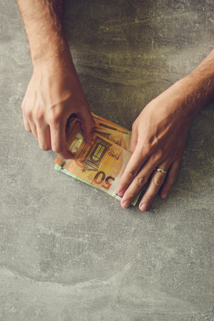 Euro banknotes in man's hand, working in office