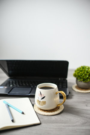 <p>Coffee mug, laptop and notebook in the office</p>の写真素材