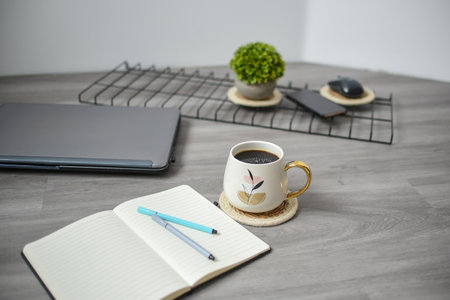 <p>Coffee mug, laptop and notebook in the office</p>の写真素材