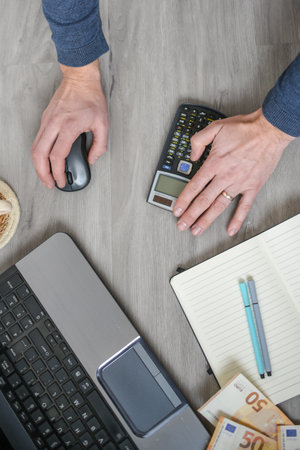 person using laptop, working and counting money in the officeの写真素材