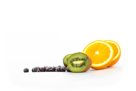 Kiwi fruit, black currants and orange on light backgroundの写真素材