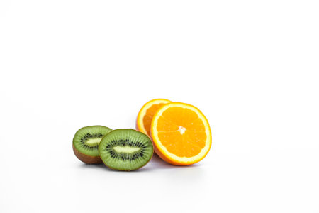 Kiwi fruit, black currants and orange on light backgroundの写真素材
