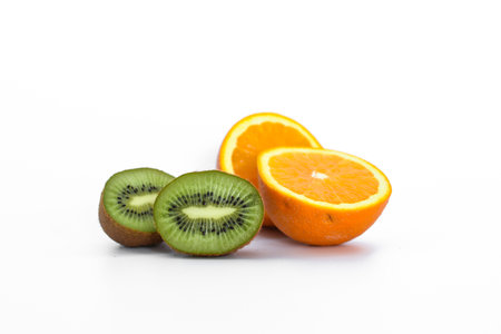 Kiwi fruit, black currants and orange on light backgroundの写真素材