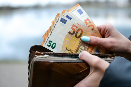 Woman is taking money from the purseの写真素材
