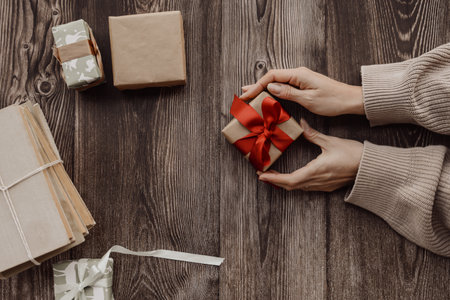 Wrapping small Christmas presents, on brown backgroundの写真素材