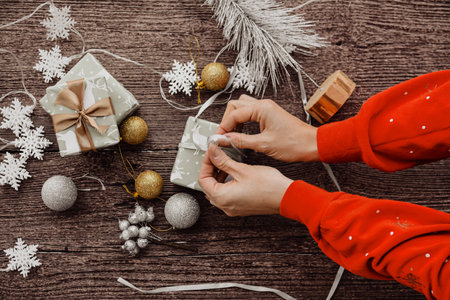 Wrapping small Christmas presents, on brown backgroundの写真素材