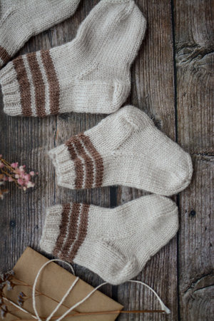 Brown baby socks made of soft cotton yarn, o dark wooden backgroundの写真素材