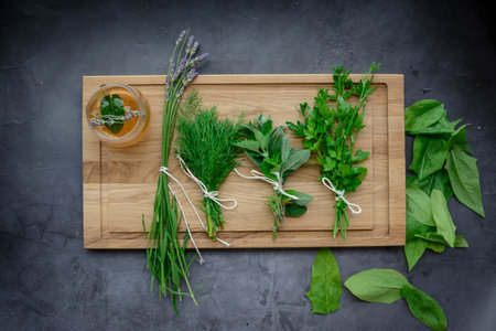 Fresh herbs on wooden cutting board. Herbs and spices on dark backgroundの写真素材