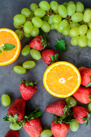 Strawberry, orange and grape on grey background. Flat layの写真素材