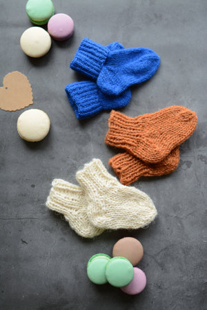 Colorful macaroons and knitted socks on grey background.の写真素材