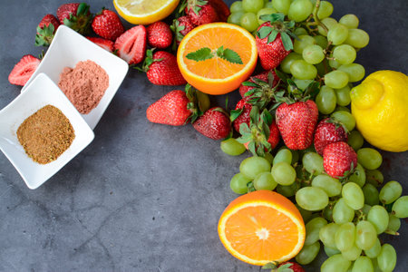 Strawberry, orange, grape, spices on dark backgroundの写真素材