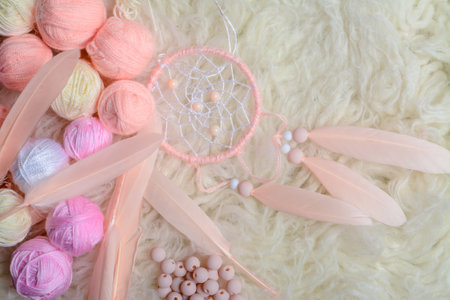 Close up of pink feathers with dreamcatcher on white fur backgroundの写真素材