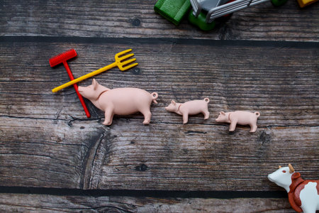 Pig toys on a wooden background. The concept of farming.