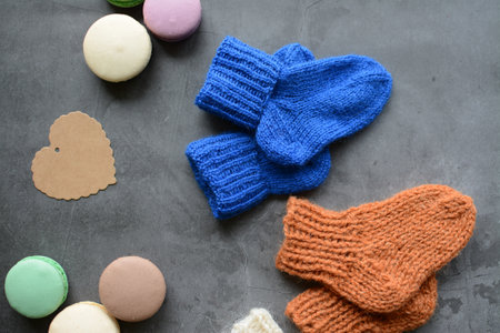 Colorful macaroons and knitted socks on grey background.の写真素材