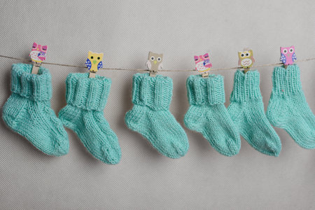 Cute baby socks hanging on a clothesline on a white backgroundの写真素材