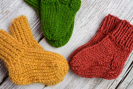 Knitted woolen socks on a white wooden background. Knitted socks.の写真素材