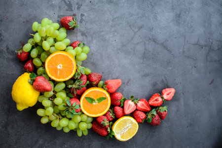 Fruit background with strawberries, grapes, oranges and lemons. Top view with copy spaceの写真素材