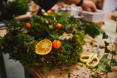 Florist making a beautiful advent wreath of succulents and orangesの写真素材