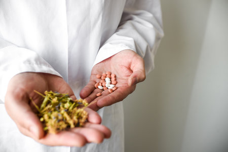 Close-up image of male doctor holding pile of pills and capsules and herbs in the other handの写真素材