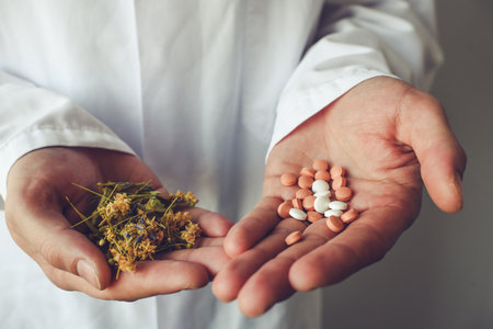 Close up of man hands holding a handful of pills and dried flowersの写真素材