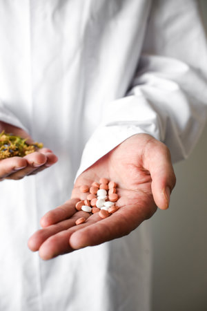 Close-up of pills in the hands of a doctor. Focus on foreground.の写真素材