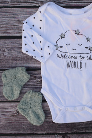 Baby clothing on a wooden background. Baby clothes and accessories. Top view.