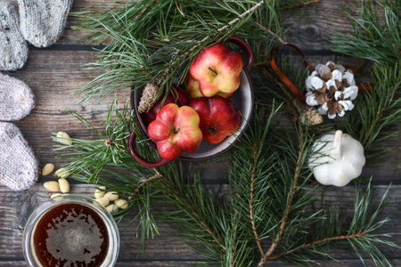 Cup of tea, apples and pine branches on a wooden backgroundの写真素材