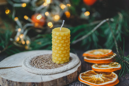 Christmas still life with burning candle and dried orange slices on a wooden background