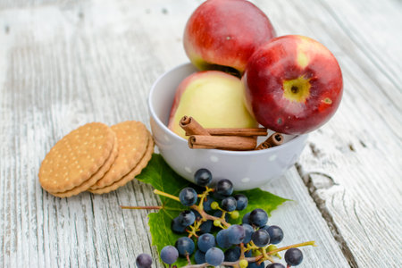 Apples, grapes and crackers on a wooden background. Selective focus.の写真素材