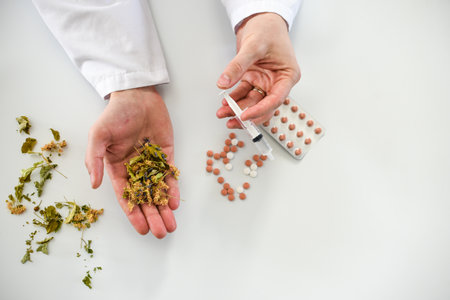 Close-up of doctor's hands holding pills and syringe on white backgroundの写真素材