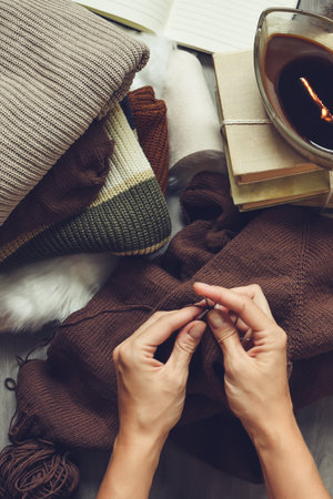 Female hands knitting woolen clothes, top view. Cozy home conceptの写真素材
