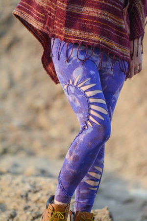 Close up of a woman's legs in blue leggings and a shawlの写真素材