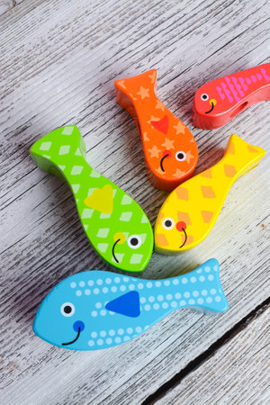 Colorful fish on a white wooden background, close-up.の写真素材