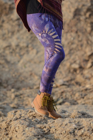 Legs of a woman in traditional clothes walking on the ground.の写真素材