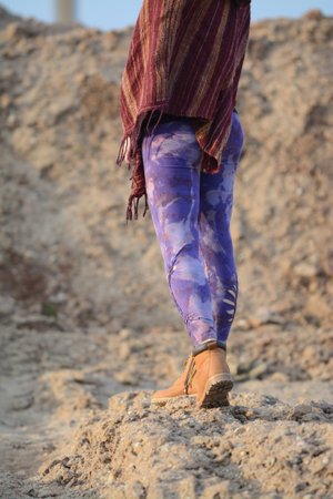 Woman walking on the sand in the desert, wearing traditional clothes.の写真素材