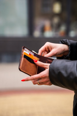 Close-up of a woman holding an empty wallet in the streetの写真素材
