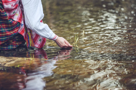Woman in national Lithanian clothes standing in the water.の写真素材