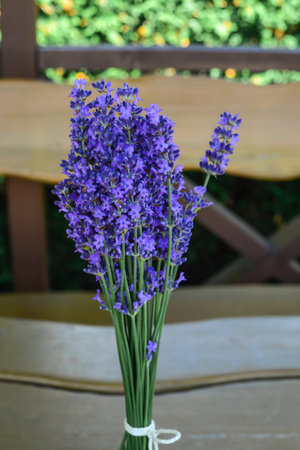 Lavender flowers in a vase on a wooden table.の写真素材
