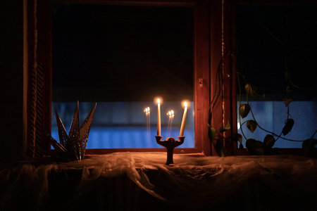 Burning candles in a candlestick on a dark background. Selective focus.の写真素材