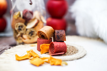 Freshly rolled, homemade fruit leather and dried fruit slices made from organic ingredients are displayed on a rustic tableの写真素材