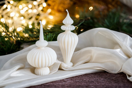 Christmas and New Year background with white candles, fir branches, bokeh and golden lightsの写真素材