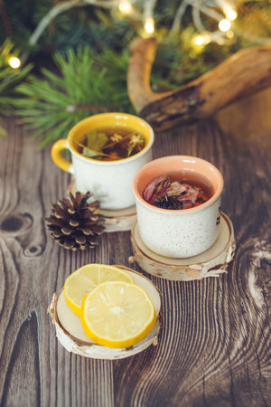 Cups of tea with lemon on a wooden table, Christmas backgroundの写真素材